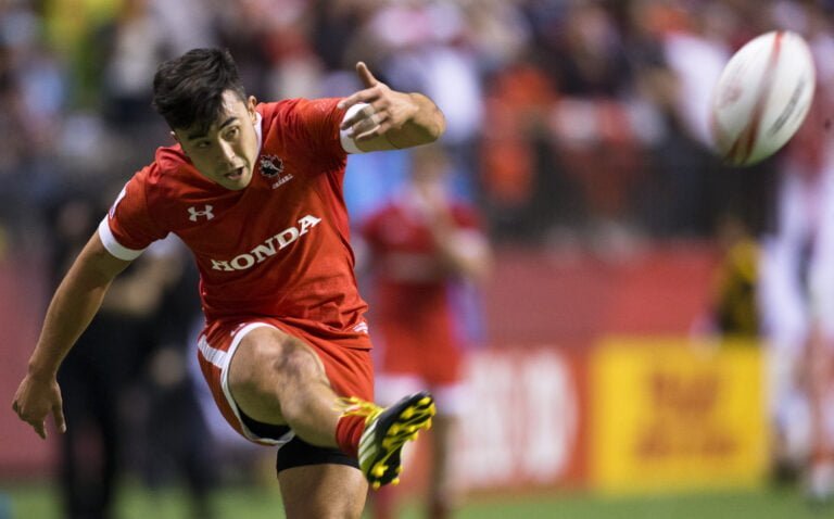 Nathan Hirayama kicks a rugby ball